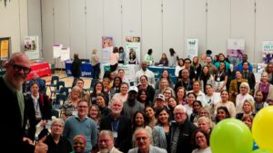 A large group of people gathered indoors at an event.