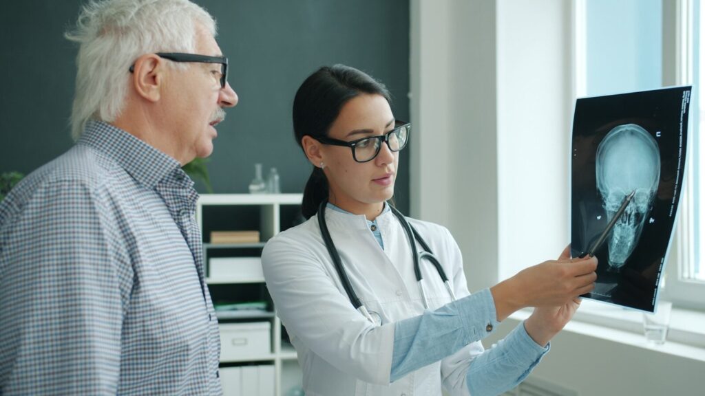Doctor shows x-ray scan to an elderly patient.