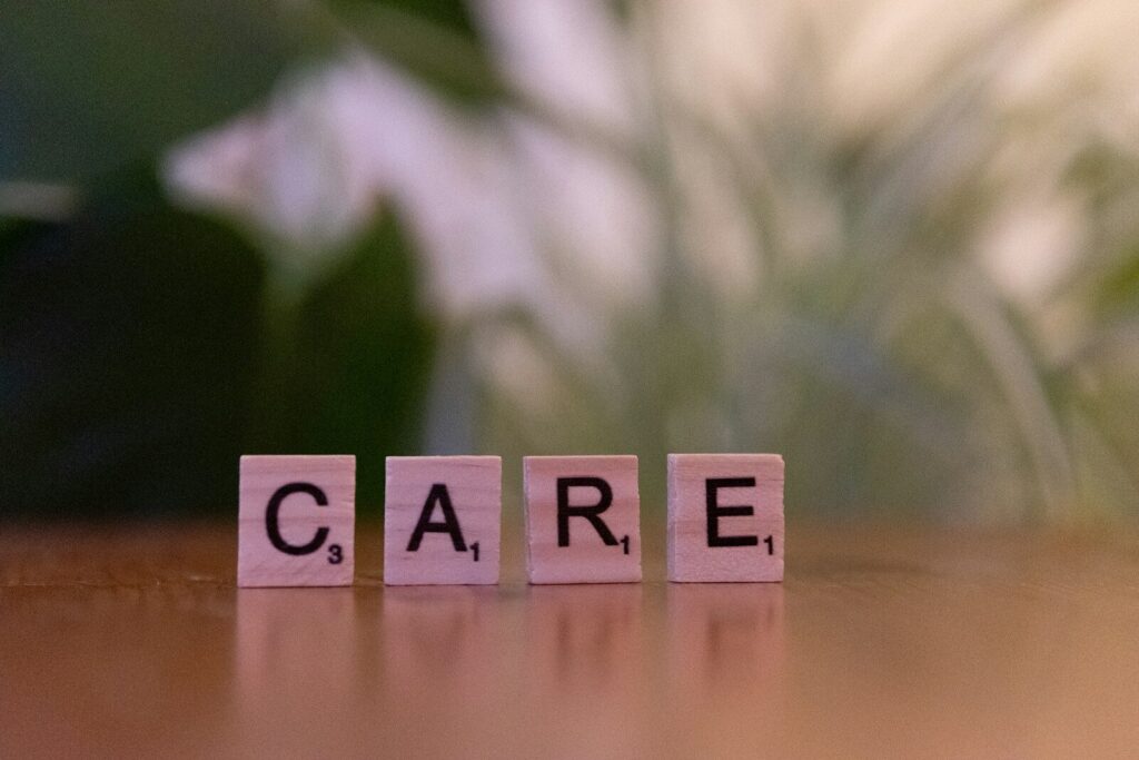 A wooden block spelling care on a table