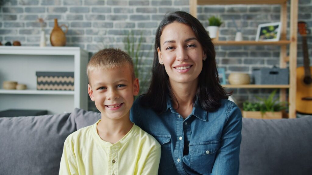 Mother and son smiling on a couch
